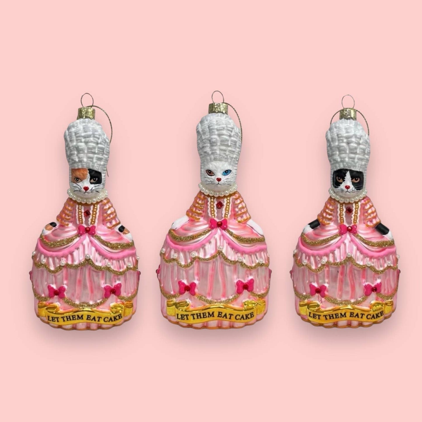 Christmas bauble featuring a white cat named Marie Antoinette, “Let Them Eat”